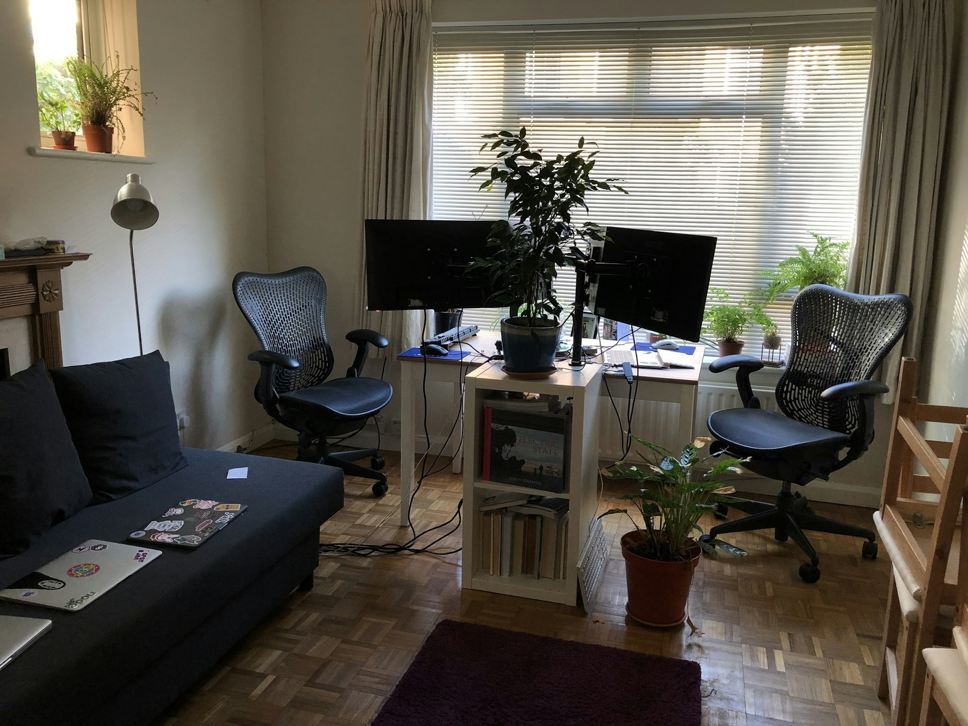 Our living room, a sofa, rug, long desk, two setups